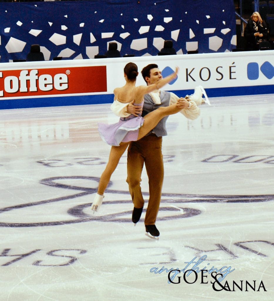 Rebecca Ghilardi and Filippo Ambrosini are doing a pair spin. Ambrosini is standing on one leg, and lifting Ghilardi by the waist and ankle while she is in a standing split.