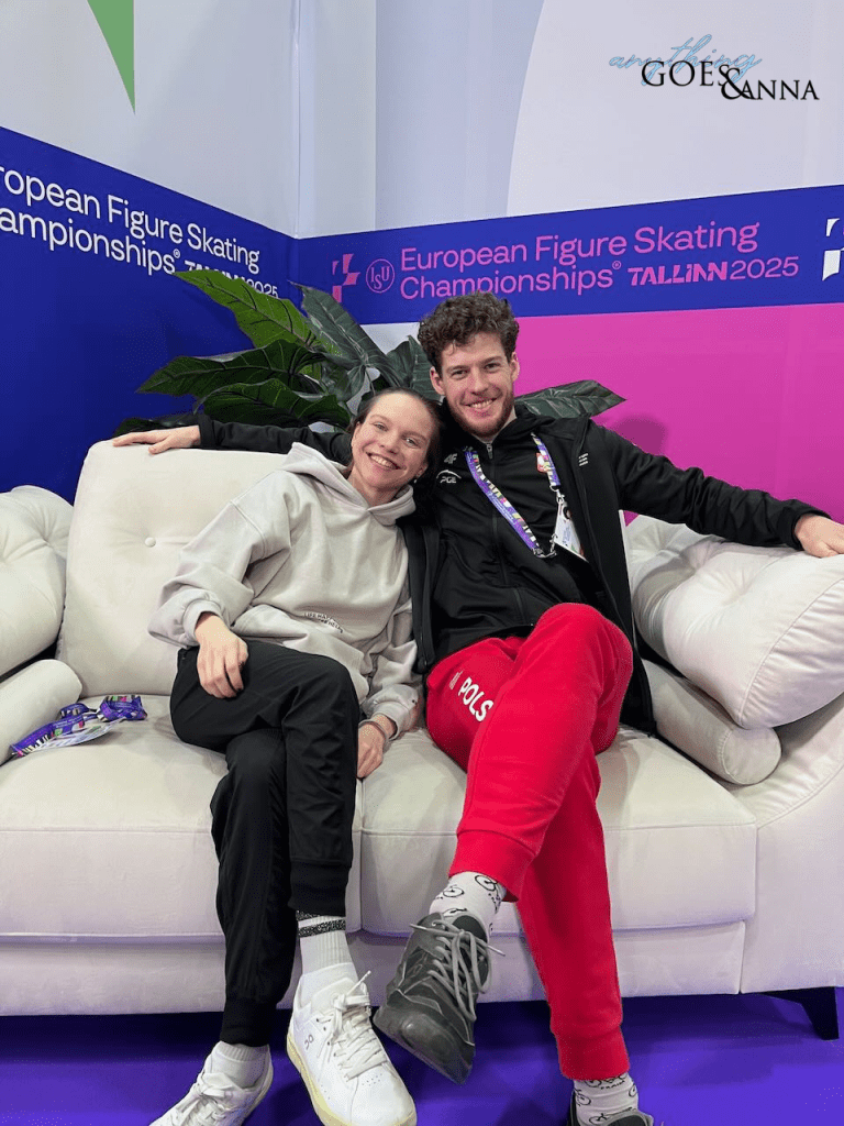 Ioulia Chtchetinina and Michal Wozniak sit on a white leather couch in the green room at the European Championships in Tallinn